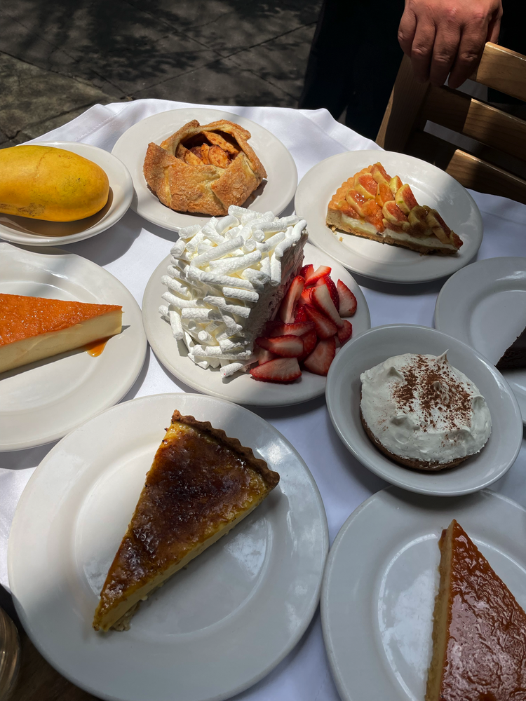 Assorted desserts and pastries on white plates, bakery display