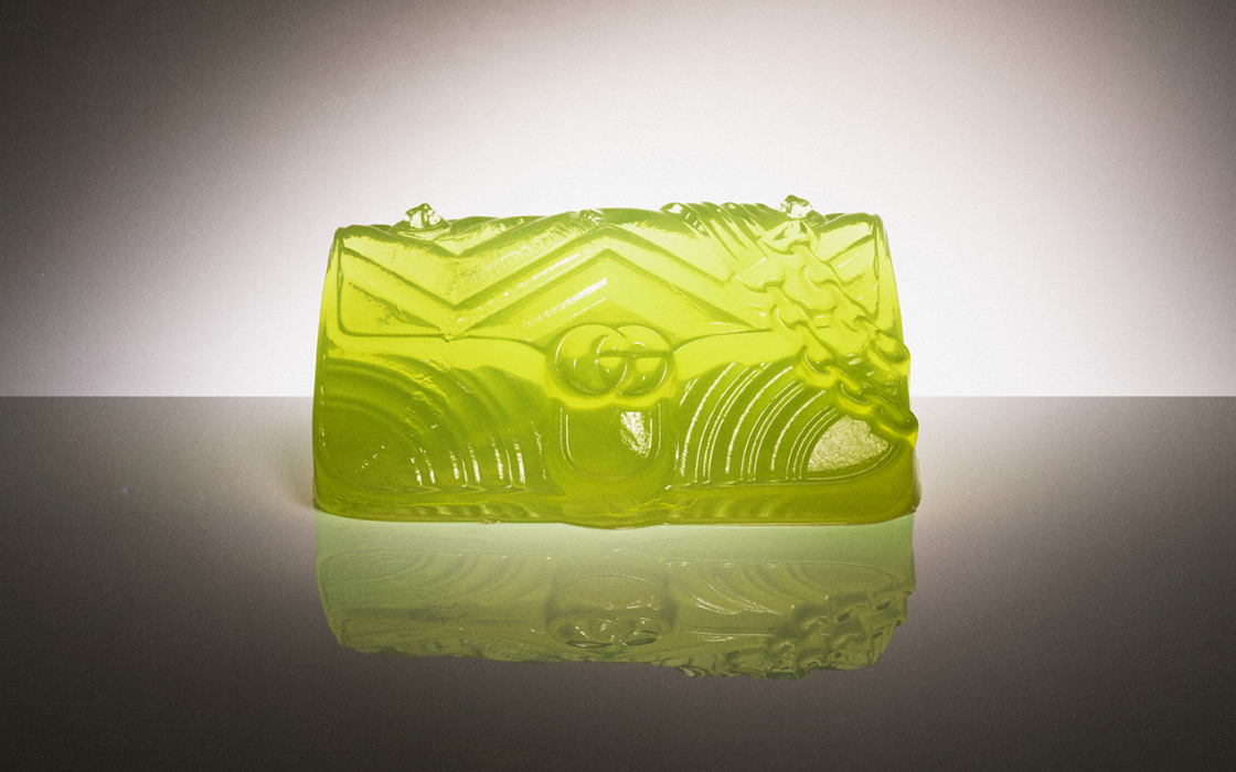 Lime green translucent Gucci clutch bag with ornate carved relief design and chain strap
