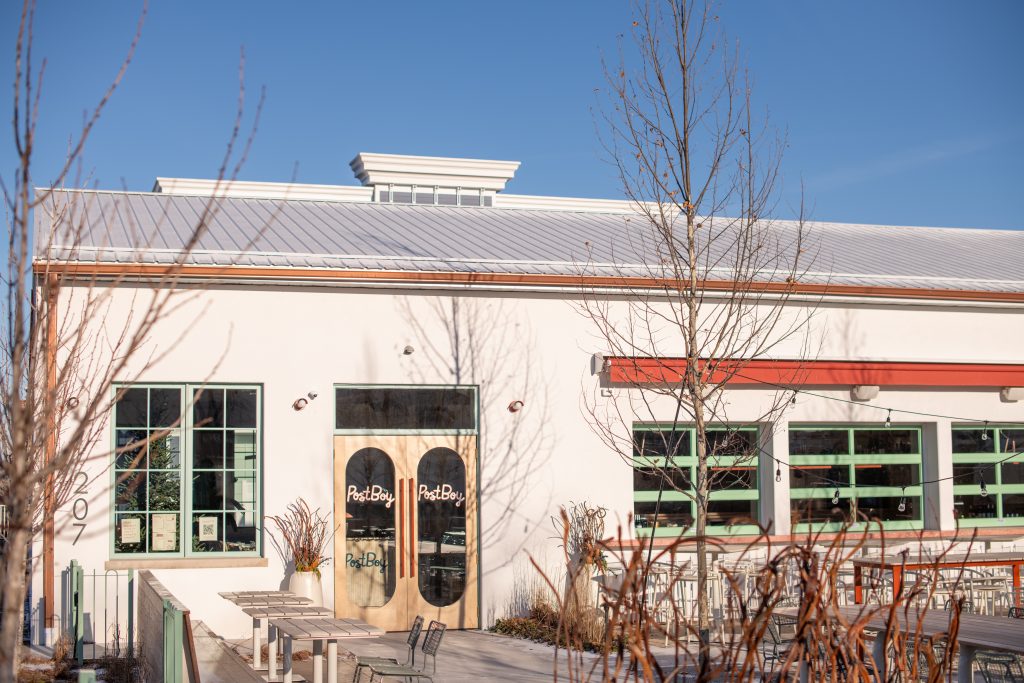 Modern commercial building with PostBoy storefront and metal roof