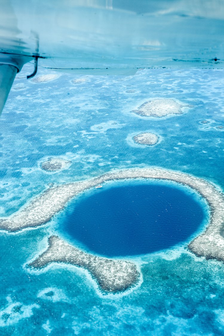 Aerial view of Great Blue Hole surrounded by coral reef and turquoise water