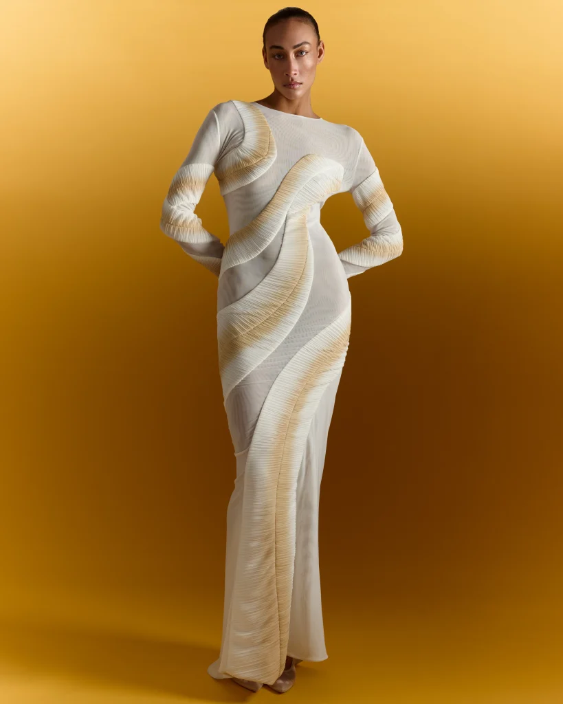 Woman wearing cream textured long-sleeve top against yellow background