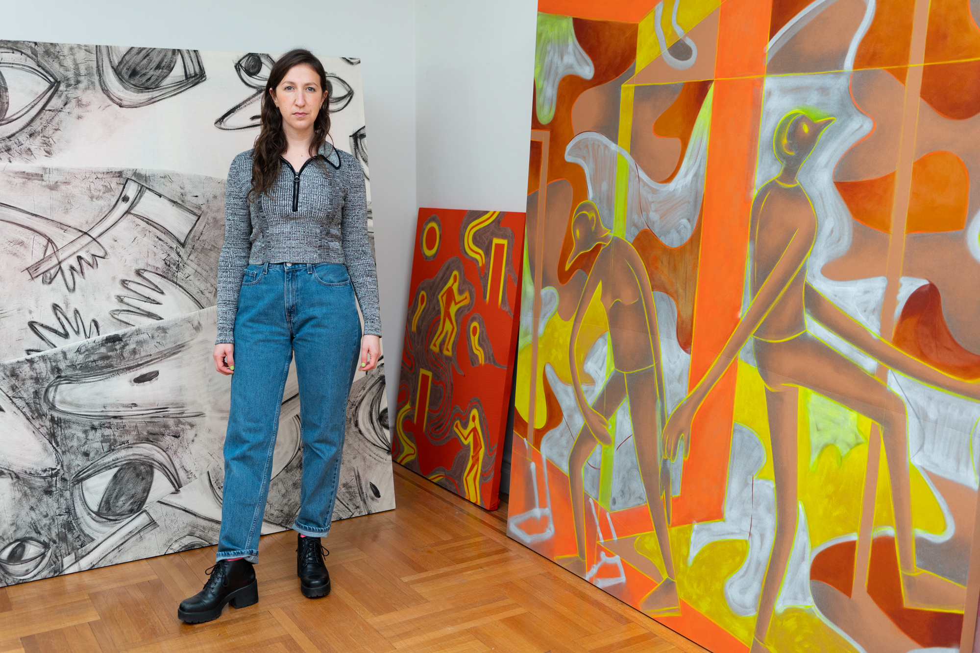 Artist standing in front of paintings