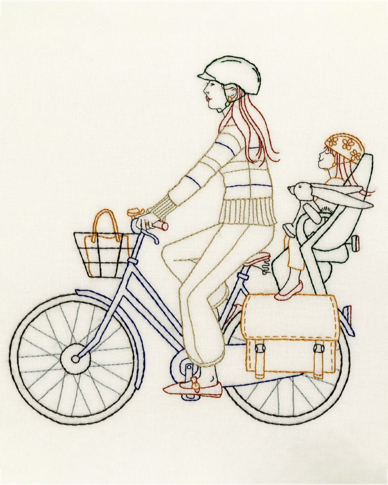 Multicolored embroidered image of a mother and her daughter on a bike.