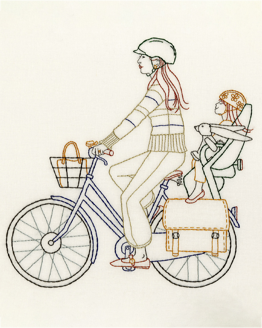 Multicolored embroidered image of a mother and her daughter on a bike.