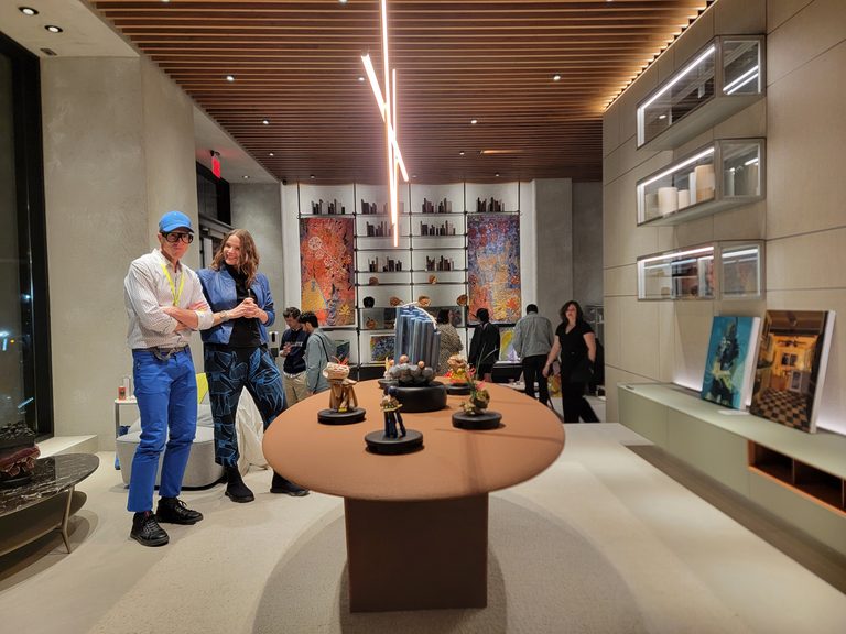 Image of an art fair with people in the background, looking at art installations.