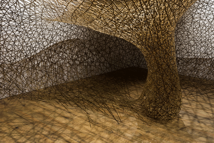 Section of a large sculpture with lattice-style detail in a gallery space