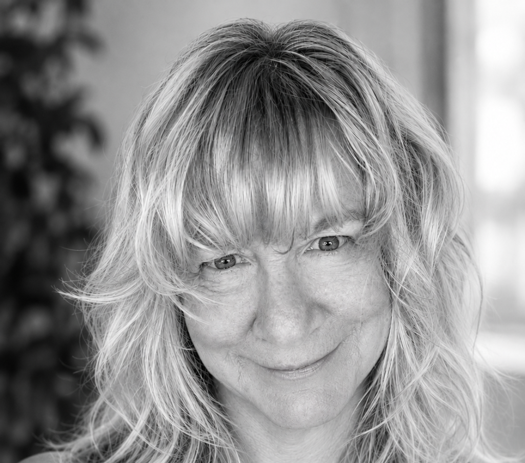 Black and white photo of a blonde woman wearing a black sleeveless top
