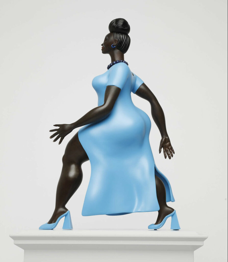 Large sculpture of a Black woman, mid-stride, wearing a blue dress